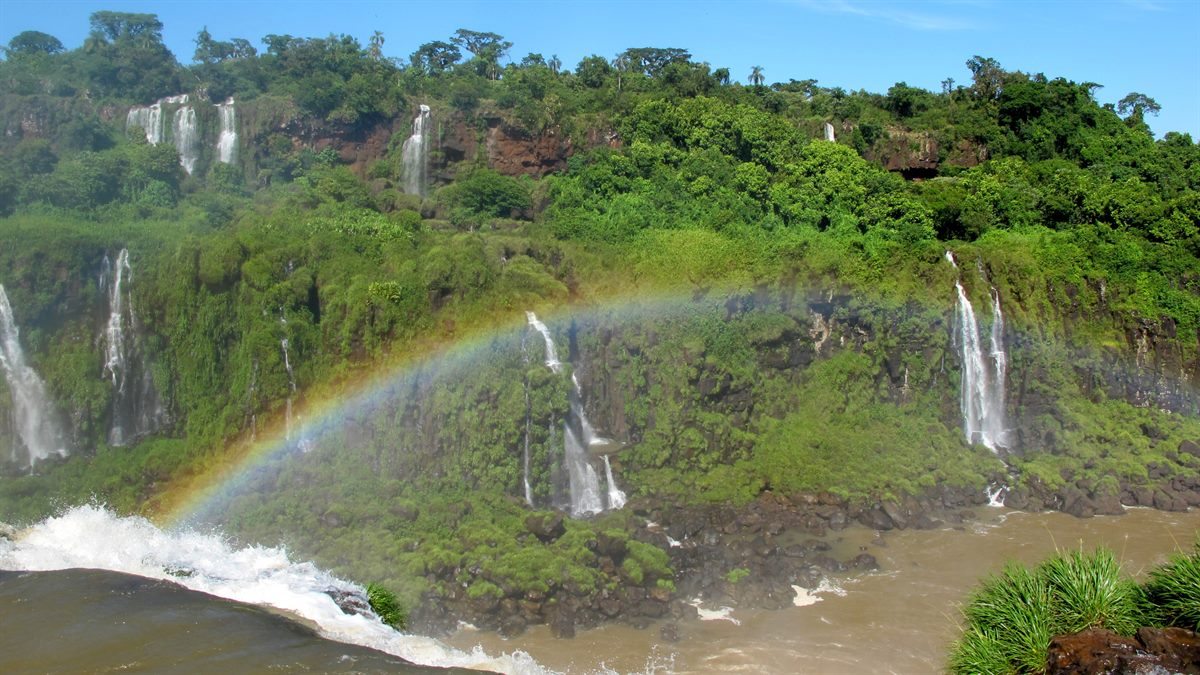 Cataratas do Iguaçu vistas do lado brasileiro, com grande volume de água e vegetação; experiência natural autêntica para turismo de aventura e ecoturismo.